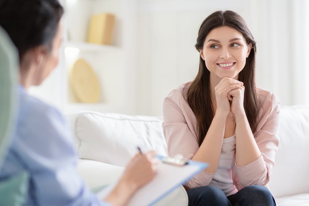 woman sitting on a sofa being interviewed