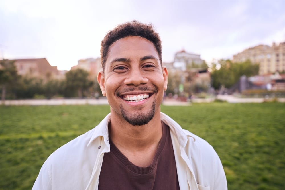 happy young man standing outdoors - Black Dentist in Columbus, Ohio